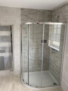walk-in shower boasts textured mosaic tiles in a slate effect
