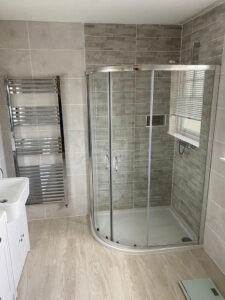 walk-in shower boasts textured mosaic tiles in a slate effect